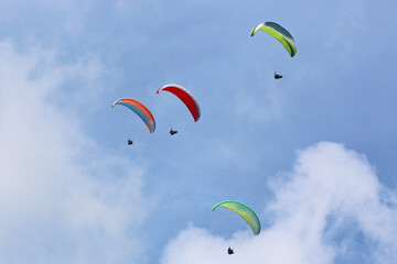 	
Paragliders in a blue sky	