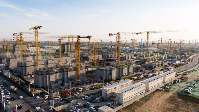 Aerial Flight Over a New Constructions Development Site with High Tower Cranes Building Real Estate. Heavy Machinery and Construction Workers are Employed. Xiongan new area of Beijing china.