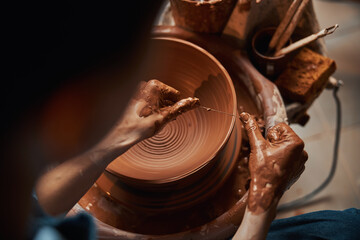 Unrecognized craft woman working in pottery workshop