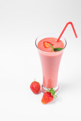 Fresh strawberry milkshake decorated with berries and mint on a white isolated background, the concept of a healthy breakfast, diet and good nutrition.