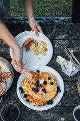 person holding a plate of pancakes