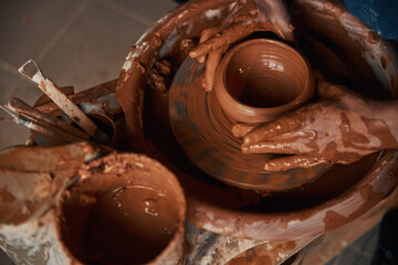 Image of process manufacturing ceramic bowl on pottery wheel in workshop