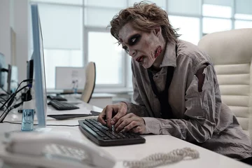 Fotobehang Ugly man with zombie makeup working with computer in office © pressmaster