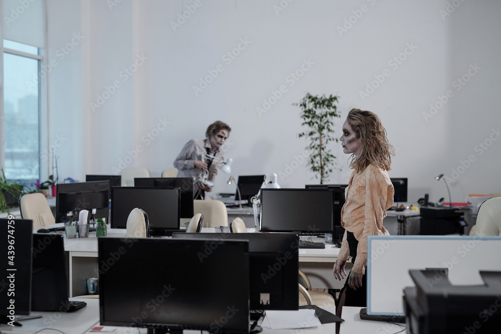 Poster zombie female moving along rows of desks in open space office