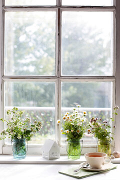 Window with a cup of tea and flowers