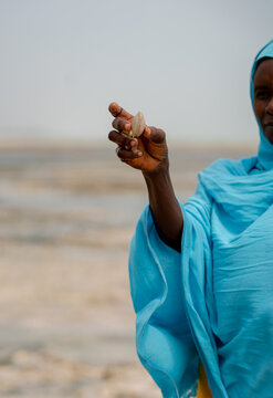 An African woman holding a shell