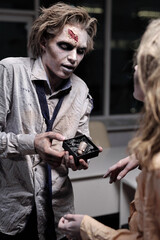 Spooky businessman with small box containing thumb looking at woman