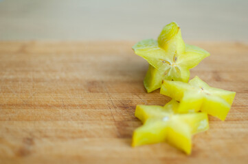 Exotic starfruit or averrhoa carambola on wooden cut board. Healthy food, fresh organic star apple fruit.