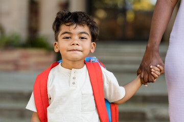 Little Boy Wearing a Red Backpack Holds His Mother's Hand 