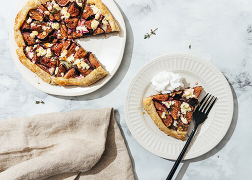 Freshly baked fig galette on with cream on plates