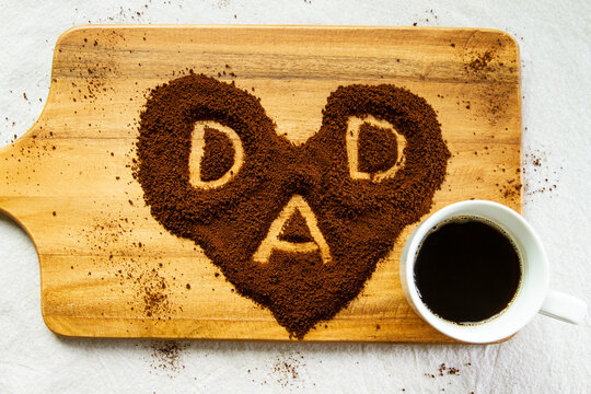 A cup of coffee with heart shaped coffee beans. Conceptual image for celebrating fathers day.  