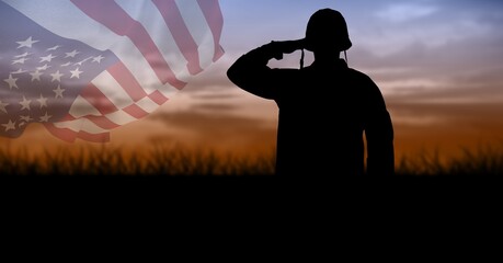 Composition of silhouette of saluting soldier against sunset sky with billowing american flag