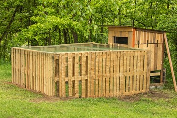 Henhouse built of wooden pallets. A small chicken coop by the forest. Hen breeding. Small farm. © martinfredy