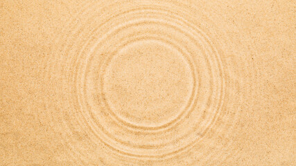 Water rings on water surface over sand. Summer texture background with round copy space