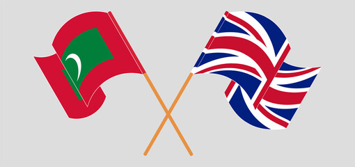 Obraz premium Crossed and waving flags of Maldives and the UK