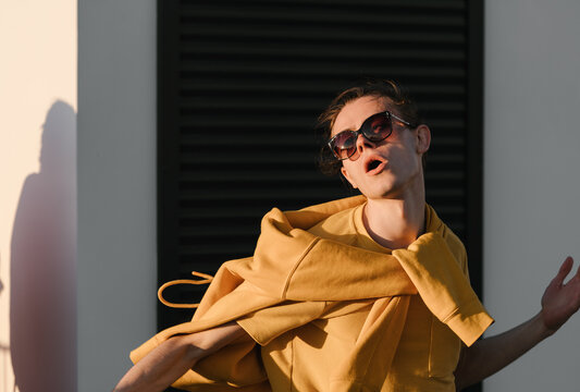 Stylish guy dancing against wall