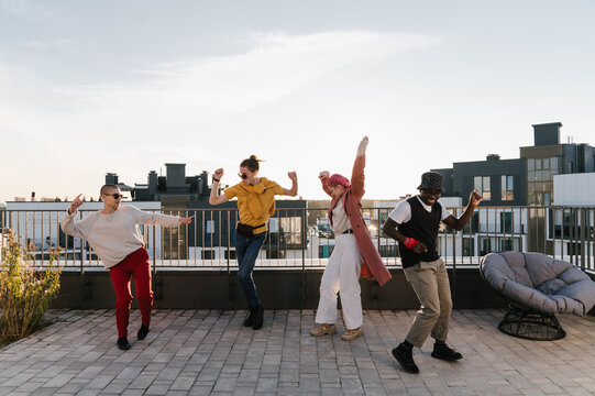 Energetic young friends dancing on rooftop