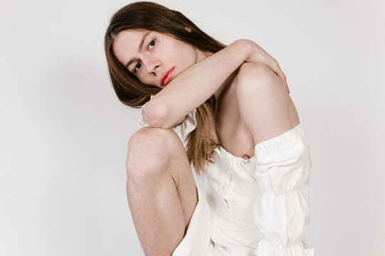 Androgynous model sitting on stool