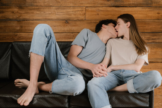 Young boyfriends kissing on sofa