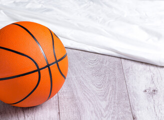 Orange basketball ball on wooden parquet. Close-up image of basketball ball over floor in the gym. Mockup flag