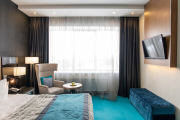 Large cozy bedroom inside modern luxurious hotel