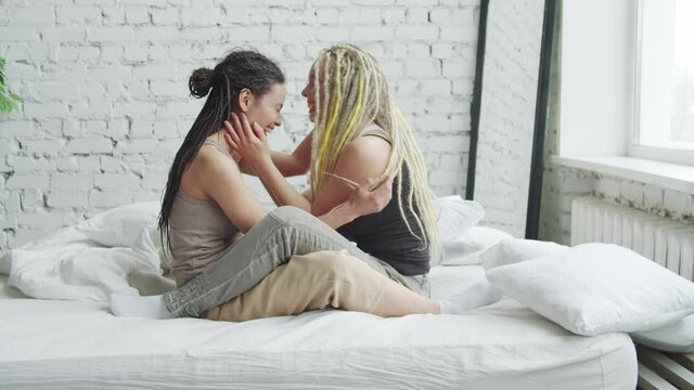 LGBT lesbian girls embracing and sharing secrets in bed