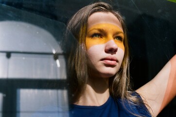 Portrait of a woman with yellow stripe on her face