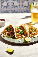 Tacos with meat and herbs, sauce and lime. National Mexican street food. On a light background.