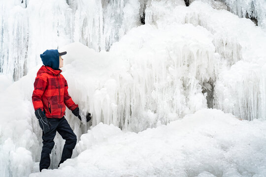 Boy at Tiffany Falls Hamilton Frozen Waterfall in Winter Landsca