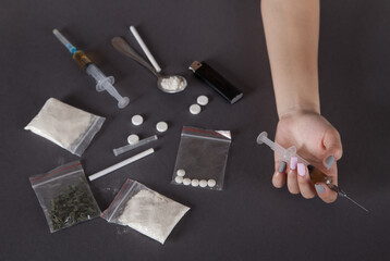 Young woman hand holding a syringe and drug.The concept of crime and drug addiction.