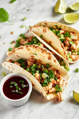 Tacos with meat and herbs, sauce and lime. National Mexican street food. On a light background.
