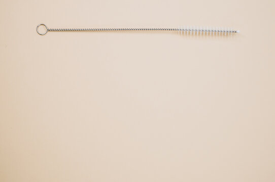 Top view of straw cleaning brushisolated on light brown background