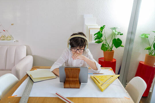 Front view of a Boy designing a project and using a tablet