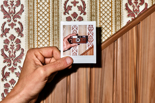 man with an instant photo in his hand
