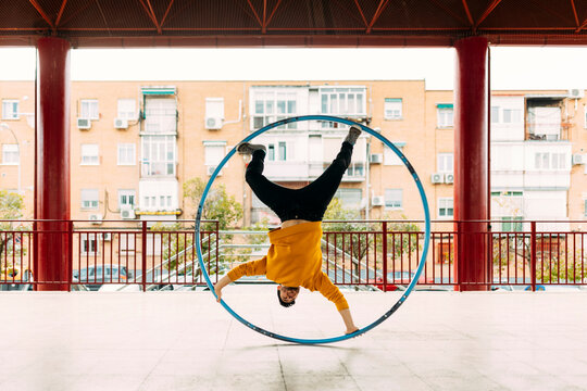 Young man performing in the street with a CYR Wheel