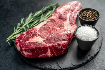 raw cowboy beef steak on stone background