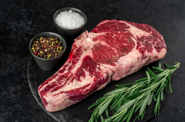 raw cowboy beef steak on stone background