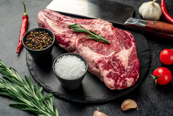raw cowboy beef steak on stone background
