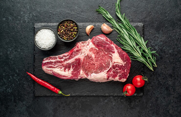 raw cowboy beef steak on stone background