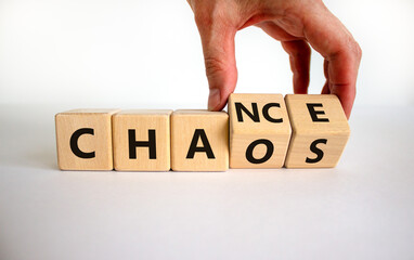 Chance or chaos symbol. Businessman turns wooden cubes and changes the word 'chaos' to 'chance'....