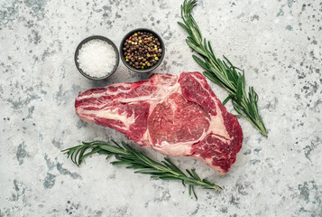 raw cowboy beef steak on stone background	