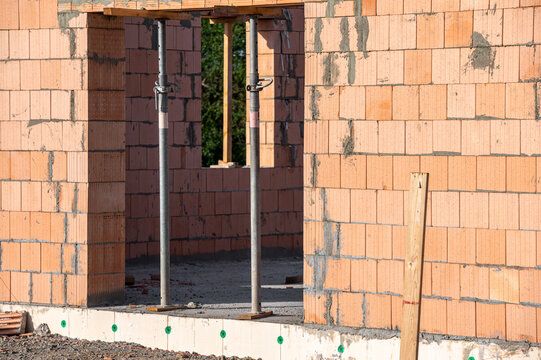 Rohbau eines Wohnhauses mit Mauerwerk und Baust&uuml;tzen