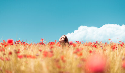 Girl enjoying the sun in a poppies field