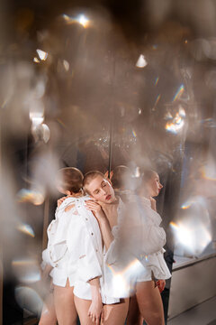 Bald woman in white shirt reflected in mirrors