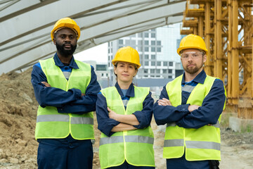 Three successful engineers or builders in hardhats and uniform