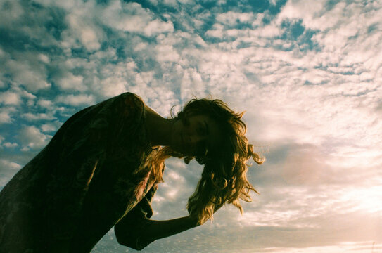 A redhead woman on a beach in front of blue sky