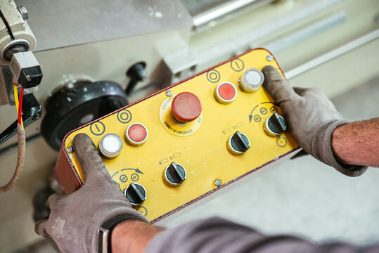 Male worker using controller and operating industrial machine