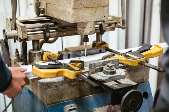 Master using drilling machine in workshop