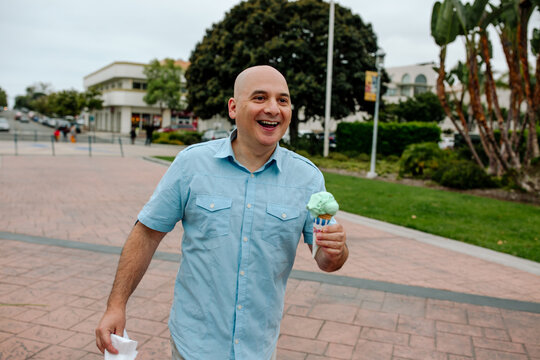 Smiling bald man with ice cream cone 