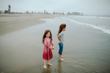 Barefoot sisters soaked by waves